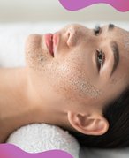 person laying on spa bed and wearing a clay mask