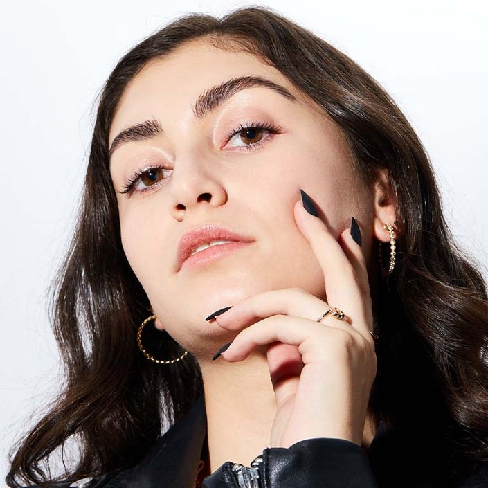 person posing with hand on chin and looking into camera