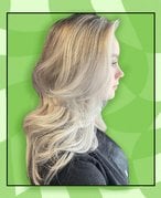 Photo of a person with blonde hair cut in a layered butterfly haircut on a green checkered background
