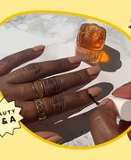 Photo of a person with tan nails applying the Essie Apricot Nail & Cuticle Oil to their cuticles, collaged on a yellow background with the Beauty Q&A logo