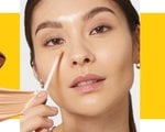 Photo of a person applying makeup to face with makeup sponge