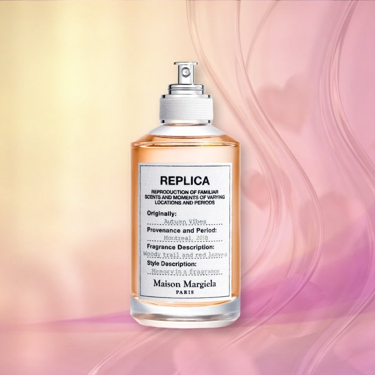 Bottle of Maison Margiela REPLICA Autumn Vibes Eau de Toilette on a pink textured background